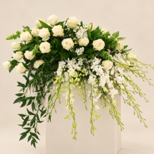Arreglo floral fúnebre en pedestal con alelí y variedad de flores blancas para condolencias en Quito.