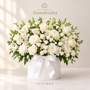 Arreglo floral fúnebre redondo en base con flores blancas y lazo decorativo para condolencias en Quito.
